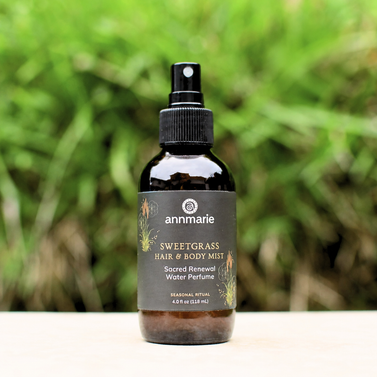 Bottle of Annmarie Sweetgrass Hair & Body Mist with a green blurred background