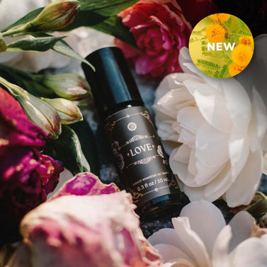 Black bottle labeled 'LOVE' surrounded by colorful flowers with a 'NEW' label in the corner.